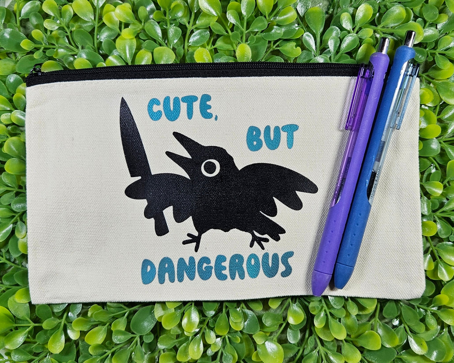 Canvas Pencil Bag with silhouette image of crow holding a knife and it says "cute, but dangerous"