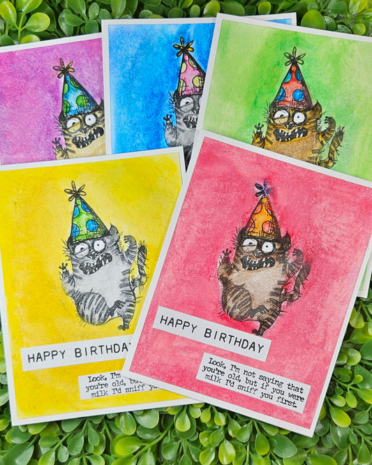 Set of colorful birthday cards with cartoon cat designs on a green leaf background