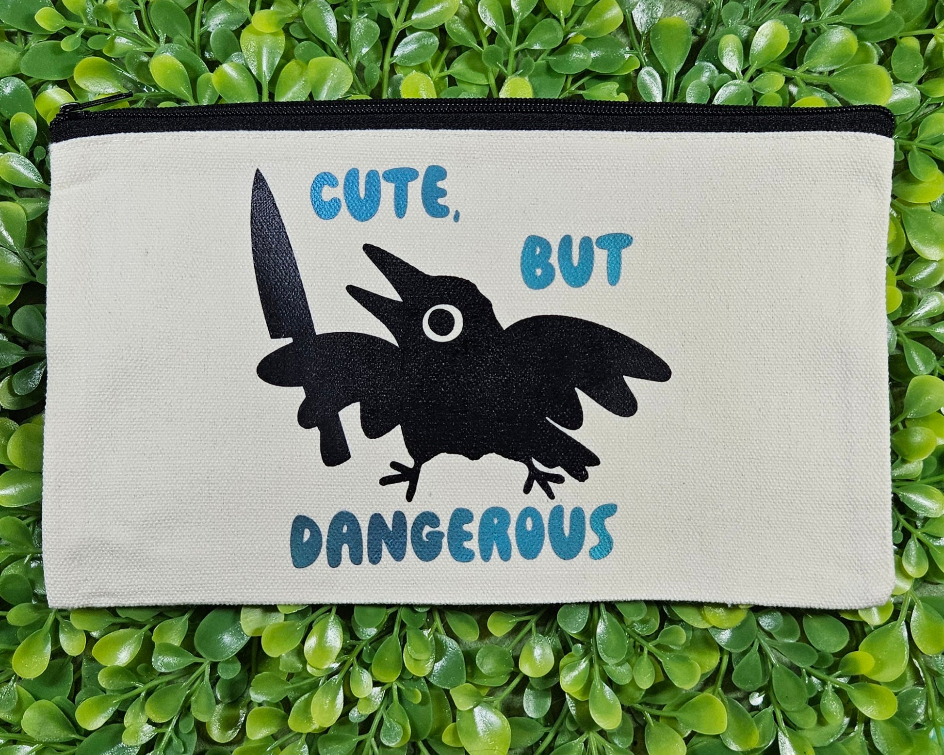 Canvas Pencil Bag with silhouette image of crow holding a knife and it says "cute, but dangerous" 